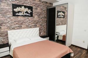 ein Schlafzimmer mit einem Bett und einer Ziegelwand in der Unterkunft Apartments Georg-Grad in Odessa