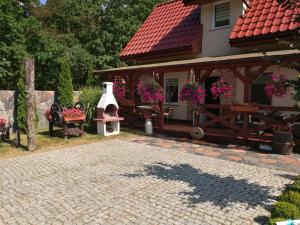 a house with a pavilion and a brick patio at Domek całoroczny Wczasy jak Marzenie in Ruciane-Nida