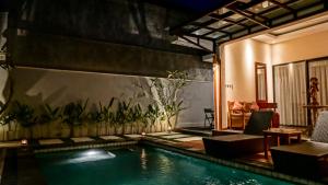a house with a swimming pool in a room at Muaya Villa in Jimbaran
