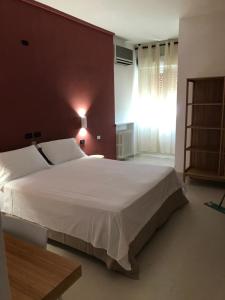 a bedroom with a large white bed and a window at Hotel Riviera in Bari