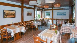 a restaurant with tables and chairs in a room at Hotel vom Land zum Meer in Jork