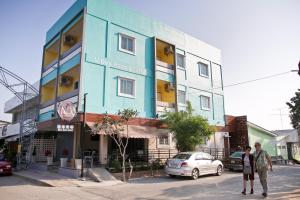 un edificio al lado de una calle con coche en U Dee Room and Coffee en Kanchanaburi