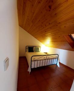 uma cama num quarto com tecto em madeira em The Beach House - Historic Center - Duna Parque Group em Vila Nova de Milfontes