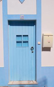 een blauwe deur op een gebouw met een brievenbus bij The Beach House - Historic Center - Duna Parque Group in Vila Nova de Milfontes