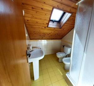 uma casa de banho com um lavatório, um WC e uma clarabóia em The Beach House - Historic Center - Duna Parque Group em Vila Nova de Milfontes