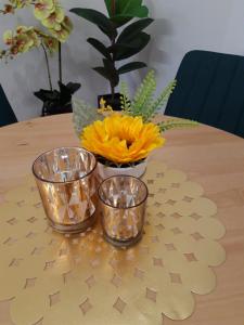 una mesa con tres tazones claros y un jarrón de flores en Mieszkanie w kamienicy en Dzierżoniów
