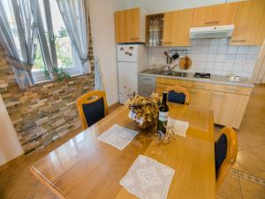 a kitchen with a wooden table with flowers on it at Apartmani Maslina in Tovrnele +10 photos