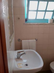 een badkamer met een wastafel, een toilet en een raam bij The Beach House - Historic Center - Duna Parque Group in Vila Nova de Milfontes