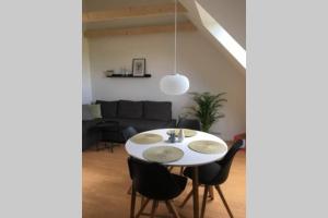 Elleholm في أودنسه: غرفة طعام مع طاولة بيضاء وكراسي