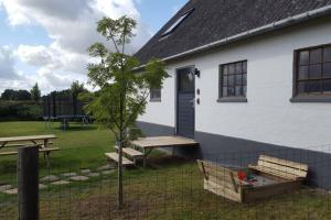a white house with a picnic table and a tree at Elleholm in Odense