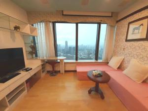 a living room with a couch and a large window at 85高雄港商旅 in Kaohsiung