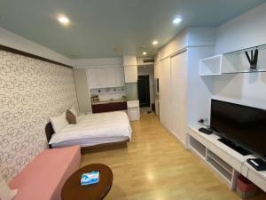 a small room with a bed and a television at 85高雄港商旅 in Kaohsiung