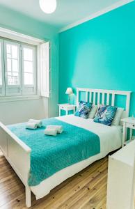 een slaapkamer met een groot bed met blauwe muren bij Lalitana Townhouse in Lagos