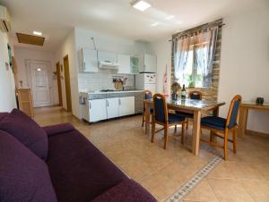 a living room with a couch and a table and a kitchen at Apartmani Maslina in Tovrnele