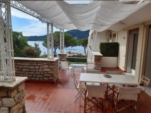 een patio met een tafel en stoelen en uitzicht op het water bij Olivo House 2 in Portovenere