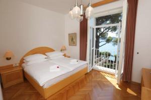 a bedroom with a bed and a large window at Vila Tartini in Strunjan