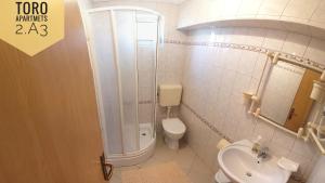 a bathroom with a toilet and a shower and a sink at Apartments TORO Pag in Pag +63 photos