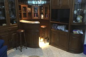 a bar with stools and a television in a room at Charming Family Large Apartment in Bragança