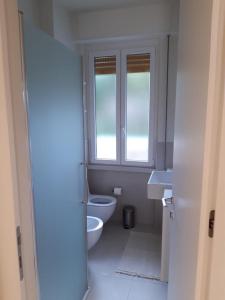 een badkamer met een toilet, een wastafel en een raam bij Olivo House 2 in Portovenere