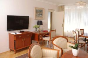 a living room with a television and a table and chairs at Vila Tartini in Strunjan