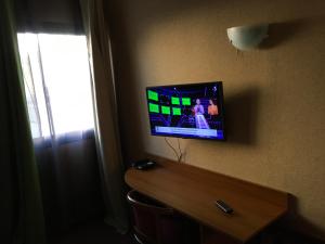 einen Fernseher an der Wand in einem Hotelzimmer in der Unterkunft Hotel Dorele in Montargis