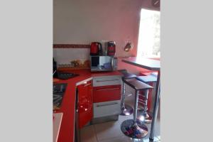 a kitchen with red counters and a red counter top at La Kaz d'Évania in Sainte-Rose
