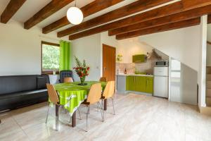 cocina y comedor con mesa verde y sillas en Morena house, en Niechorze