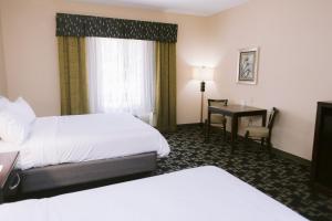 a hotel room with two beds and a desk at Holiday Inn Express Hotel Raleigh Southwest, an IHG Hotel in Raleigh