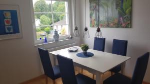 un tavolo da pranzo con sedie blu e una finestra di Ferienwohnung Wichmannsberg a Hameln