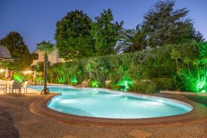 uma piscina num jardim à noite em Aristides Hotel em Fourka