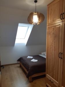 a bedroom with a bed and a window and a light at Apartament Modrzewiowy Raj in Kluszkowce