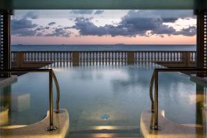 a swimming pool with a view of the ocean at GH Palazzo Suite & SPA in Livorno