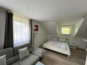 ein Schlafzimmer mit einem Bett und einer Couch in der Unterkunft Ossiach Apartment 1 in Heiligen Gestade