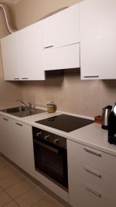 a kitchen with white cabinets and a black sink at AKANTHO apartment in Mantova