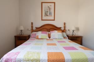 ein Schlafzimmer mit einem Bett mit einer bunten Steppdecke in der Unterkunft Villa Javi in Riumar + 13 Fotos