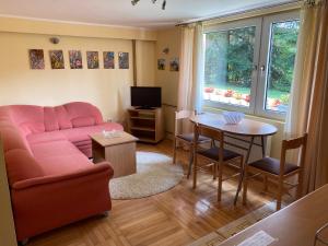 a living room with a pink couch and a table at Dusa Zlatibora in Zlatibor