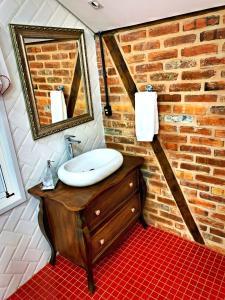 ein Badezimmer mit einem Waschbecken und einer Ziegelwand in der Unterkunft Aconchegante Casa de Hospedagem Enxaimel in Timbó