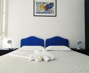 ein Bett mit zwei weißen Kissen und einem blauen Kopfteil in der Unterkunft IL DUOMO in Cesena