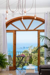 un soggiorno con una grande porta a vetri con vista sull'oceano di Villa genny and emily a Positano