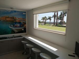 een badkamer met een groot raam met krukken en een wastafel bij Villa Cleofe in Tuglie