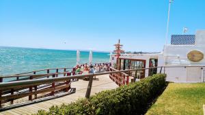 a pier with people standing on it next to the ocean at Casa Cachita-En 1ª línea de playa in Estepona