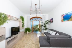 een woonkamer met een bank en een tv bij Villa genny and emily in Positano