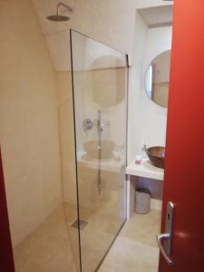 W łazience znajduje się szklana kabina prysznicowa i umywalka. w obiekcie Nel cuore di Ostuni w mieście Ostuni