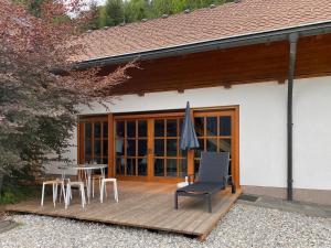 eine Holzterrasse mit einem Tisch und einem Stuhl darauf in der Unterkunft Jované in Bad Kleinkirchheim