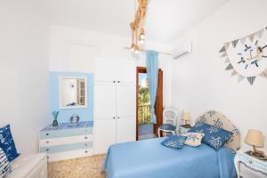 a bedroom with a blue bed and a chair at Villa genny and emily in Positano