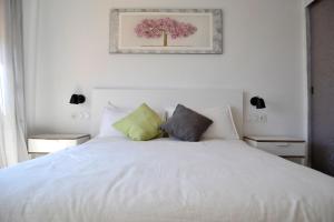a bedroom with a white bed with two pillows at El Encanto in Fuengirola +29 photos