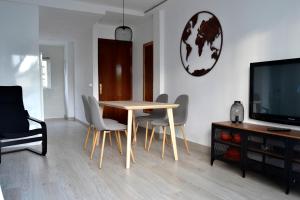 a dining room with a table and chairs and a television at El Encanto in Fuengirola