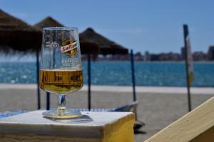 a glass of beer sitting on a table at the beach at El Encanto in Fuengirola
