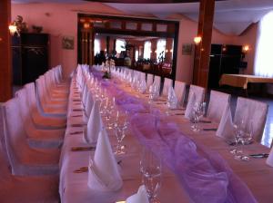 a long table with white chairs and wine glasses at Kraichtaler Hof in Kraichtal