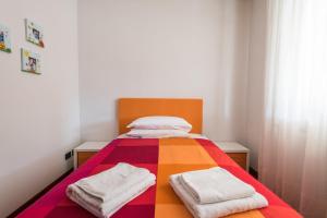 uma cama com um cobertor colorido e duas toalhas em B&B Il Sentiero dei Goti em Monte Grimano Terme